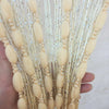 Close-up of a hand holding long strands of glitter fringe door curtain for home decor