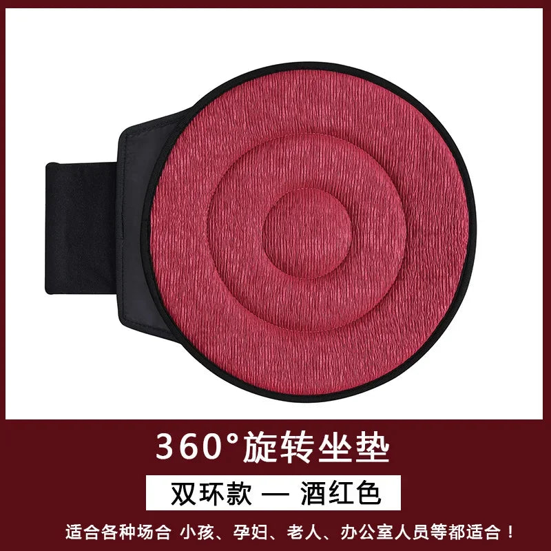 A maroon 360-degree rotating car seat cushion with a black strap.