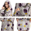 A woman wearing a gray and purple patterned plush fleece blanket hoodie.