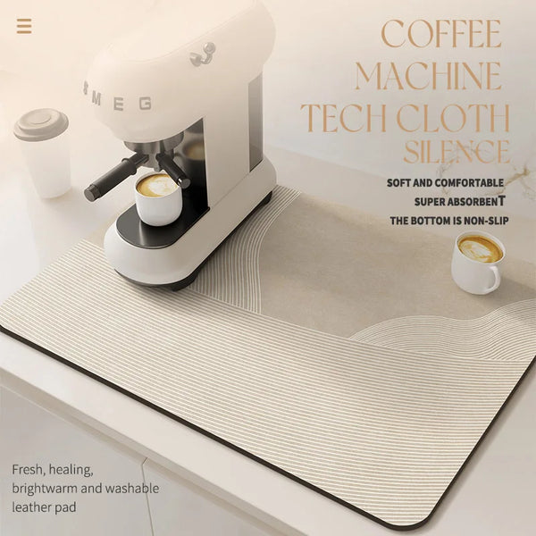 A white coffee machine is shown on a beige silicone mat with a coffee cup placed nearby.
