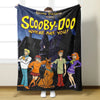 A dark flannel throw blanket featuring a Scooby-Doo themed design with characters and spooky scenery.