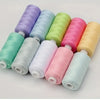 A collection of colorful polyester sewing thread spools in various shades including purple, green, pink, and yellow.