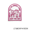 Embroidered patch with text May the Bridges I Burn Light the Way on a pink background