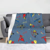 A blue flannel throw blanket featuring various horror movie weapons and symbols.