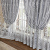 Gray vintage floral blackout curtains hanging in a window with sheer white lace undercurtains