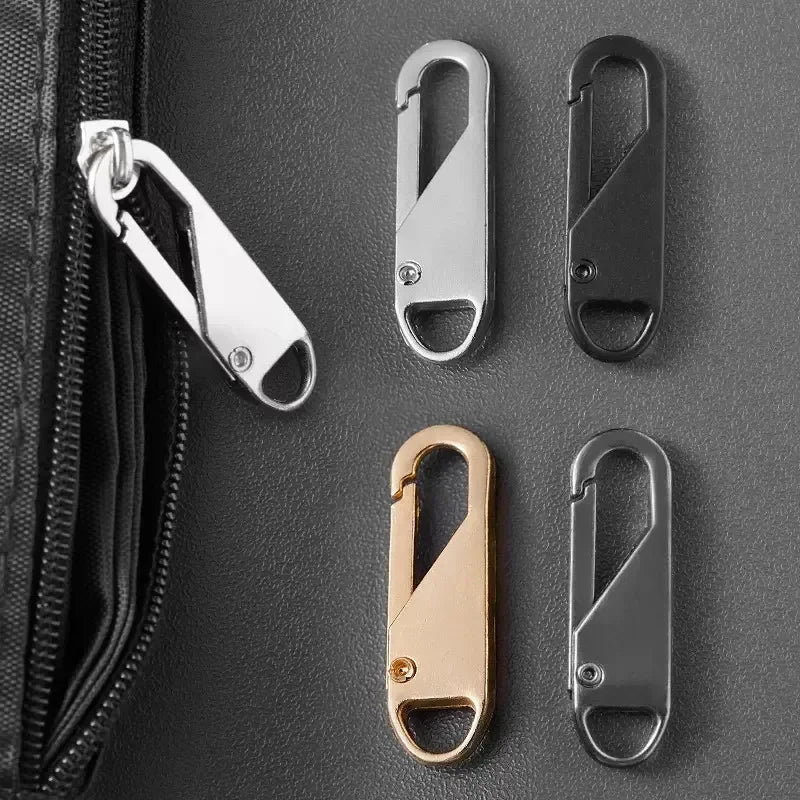 A collection of metal zipper pullers in silver and gold finishes displayed on a dark gray leather surface.