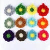 A collection of colorful flower-shaped kitchen dish scrubber sponges in various shades including green, yellow, red, purple, 