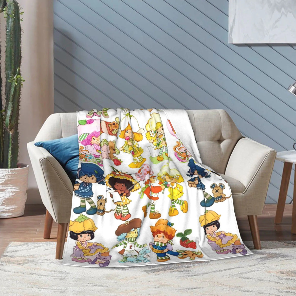 A plush throw blanket featuring Strawberry Shortcake characters in various poses and colors.