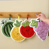 A collection of adorable floral fruit shaped coral fleece hanging hand towels on a wooden rack.