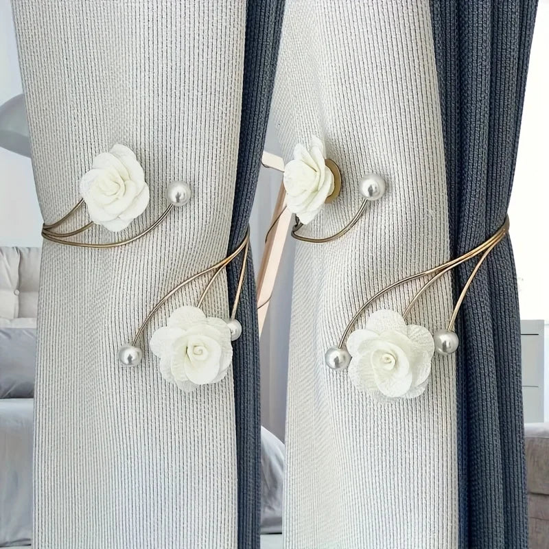 Close-up of light gray and dark blue curtains tied with elegant white rose pattern fabric and adjustable metal buckles