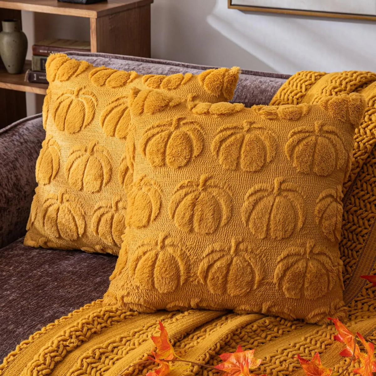 A textured, mustard yellow chenille throw pillow cover resting on a dark gray sofa.
