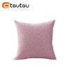 A square, dusty rose colored linen cushion cover with a button closure.