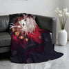 A dark purple and red circus theme soft throw blanket draped over a dark leather sofa.