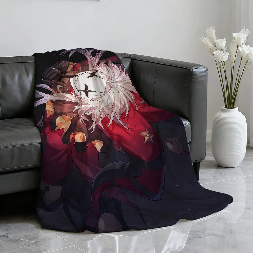 A dark purple and red circus theme soft throw blanket draped over a dark leather sofa.