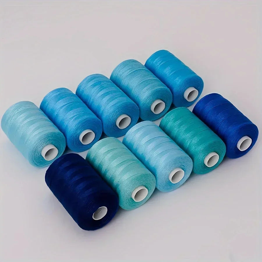 A collection of ten rolls of blue and teal polyester sewing thread arranged diagonally on a white surface.