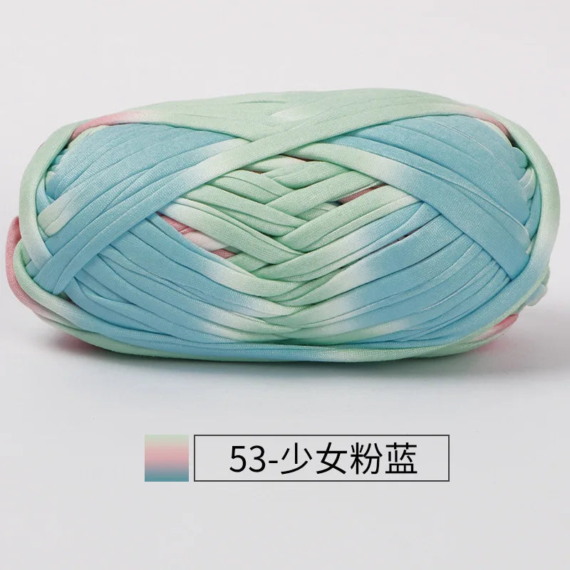 A ball of hand-dyed fabric strip yarn featuring a soft blue and green watercolor pattern for crochet and knitting.