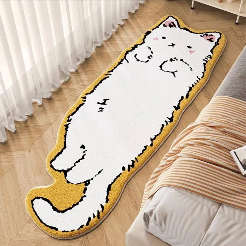 A decorative cat mat with a white body and yellow paws is placed on a wooden floor next to a bed.
