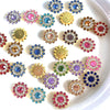 A collection of multicolor sew-on rhinestone crystals in various shades of pink, blue, and gold arranged on a white surface.