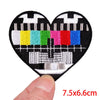 A heart-shaped embroidery patch featuring a stylized rose skull design with colorful stitching.