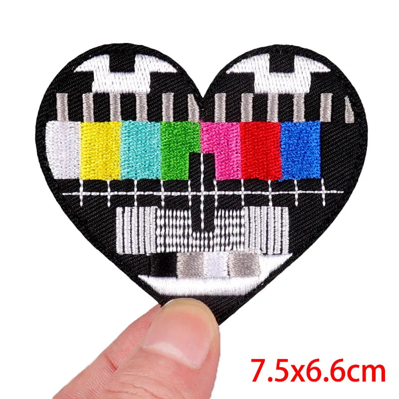 A heart-shaped embroidery patch featuring a stylized rose skull design with colorful stitching.