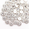 A close-up of silver crystal rhinestone sew-on buttons arranged in a sunflower pattern.