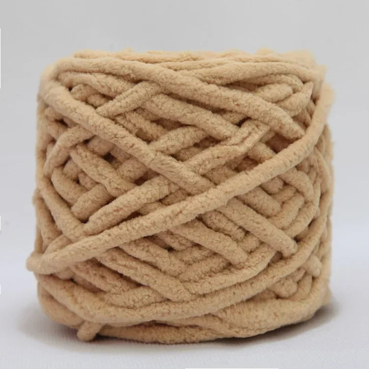 A ball of light beige chenille knitting yarn used for hand crafting.
