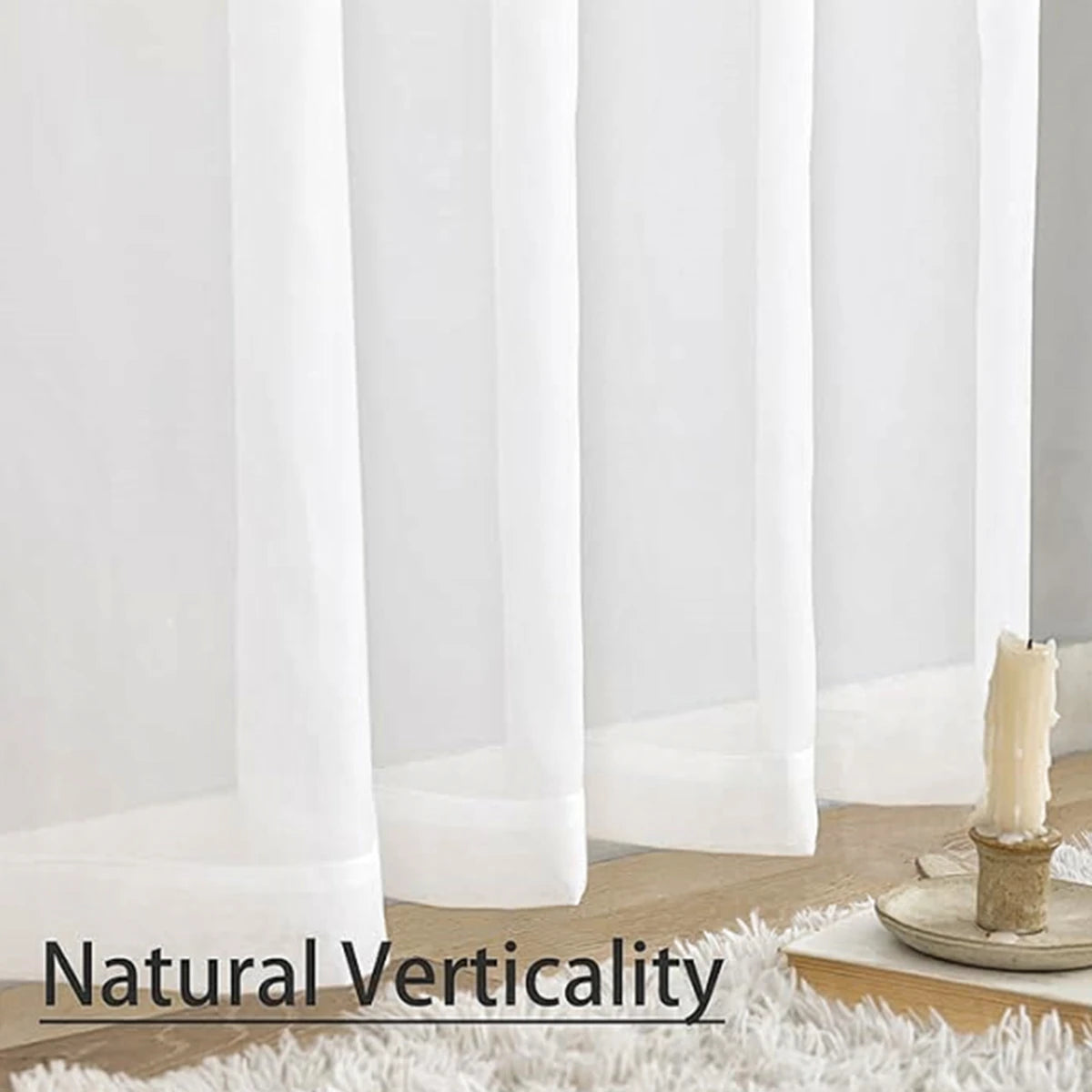 A close-up of sheer white voile curtains hanging vertically against a white wall.