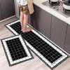 Two black and white diamond print non-slip kitchen rugs displayed on a light wood floor.