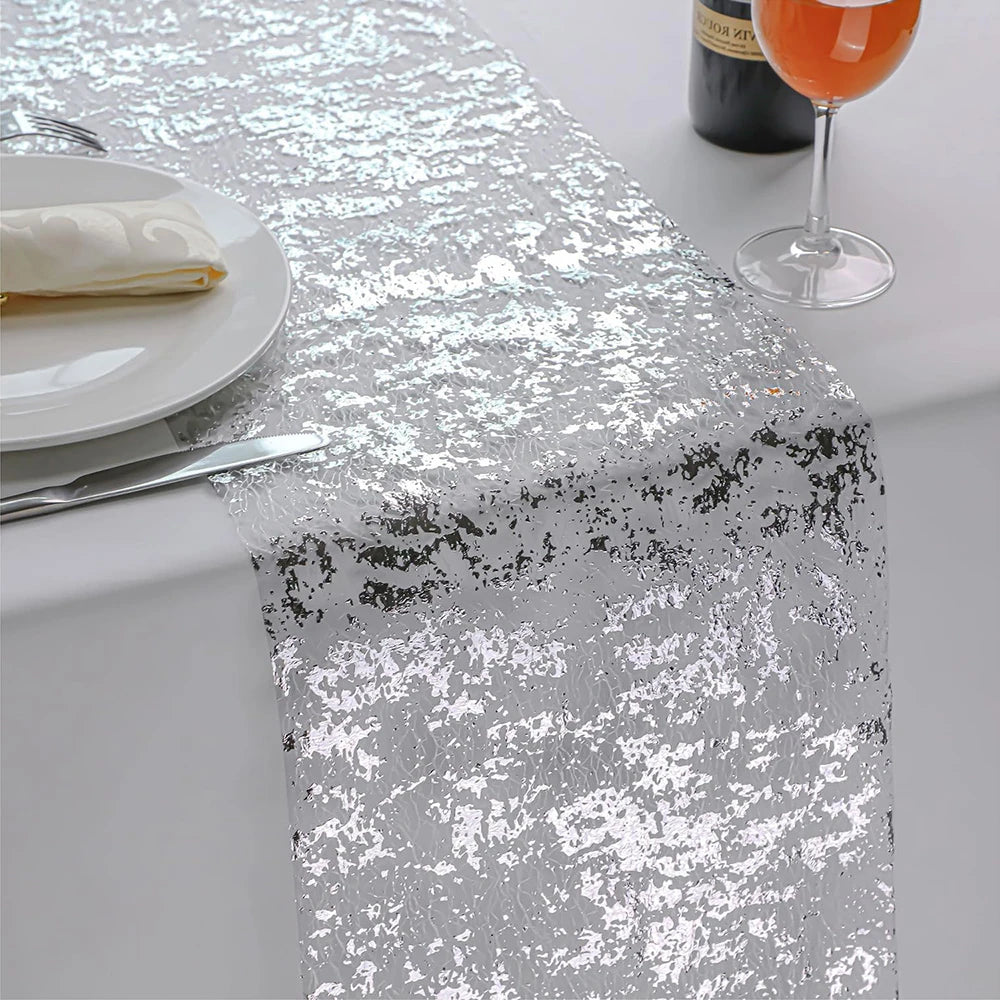 Silver glitter sequin table runner displayed on a white table with a plate and a glass of orange juice.