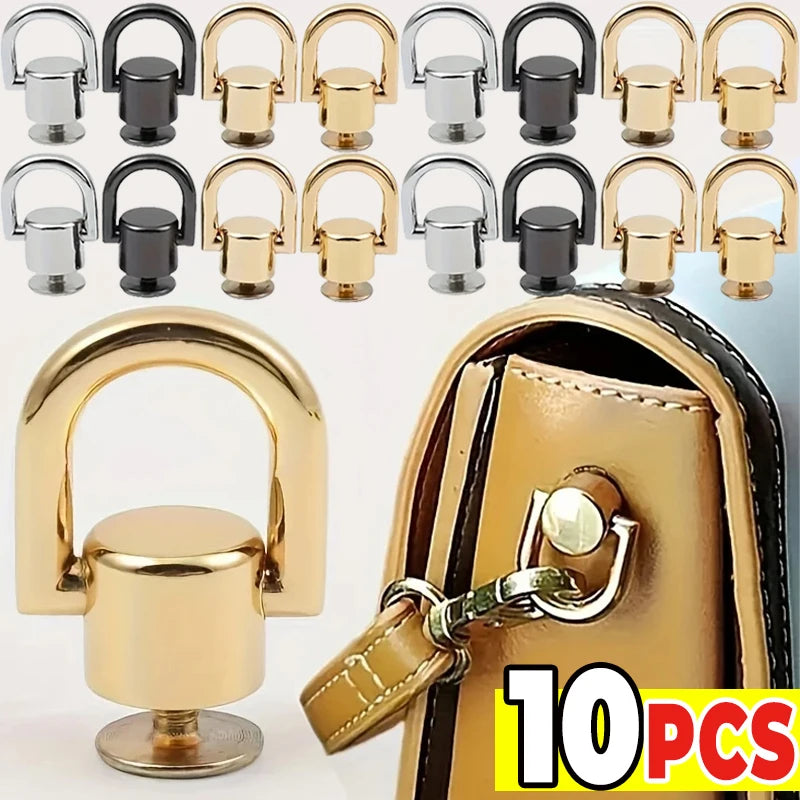 A set of ten gold and black metal D-shaped ring bag handles with screws shown next to a leather bag.