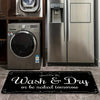 A black laundry mat with white text that reads Wash & Dry or be naked tomorrow placed on a tiled floor.