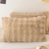A beige faux fur decorative pillow cover lying on a white surface.
