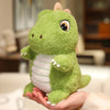 A hand is holding a cute green dinosaur plush toy with white stripes.