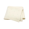 A cream-colored, knitted baby blanket folded and displayed on a white background.