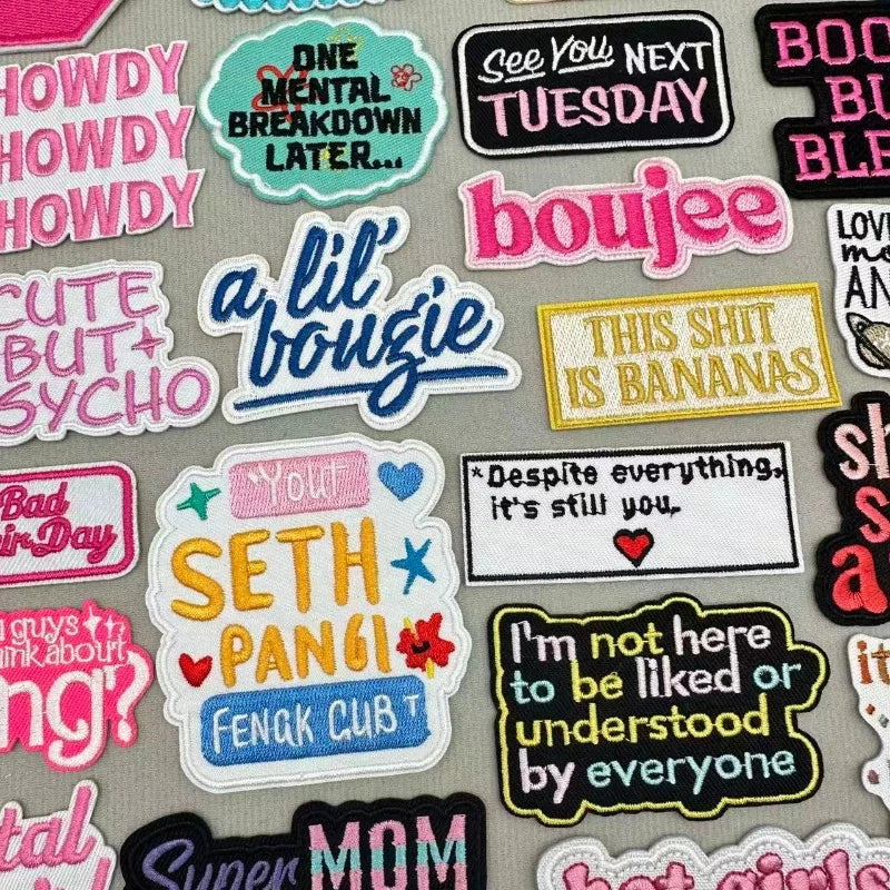 A collection of colorful embroidered slogan patches featuring text like One Mental Breakdown Later and This Shit Is Bananas