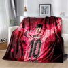A red and black soccer jersey blanket featuring Lionel Messi's number 10 design draped on a sofa.