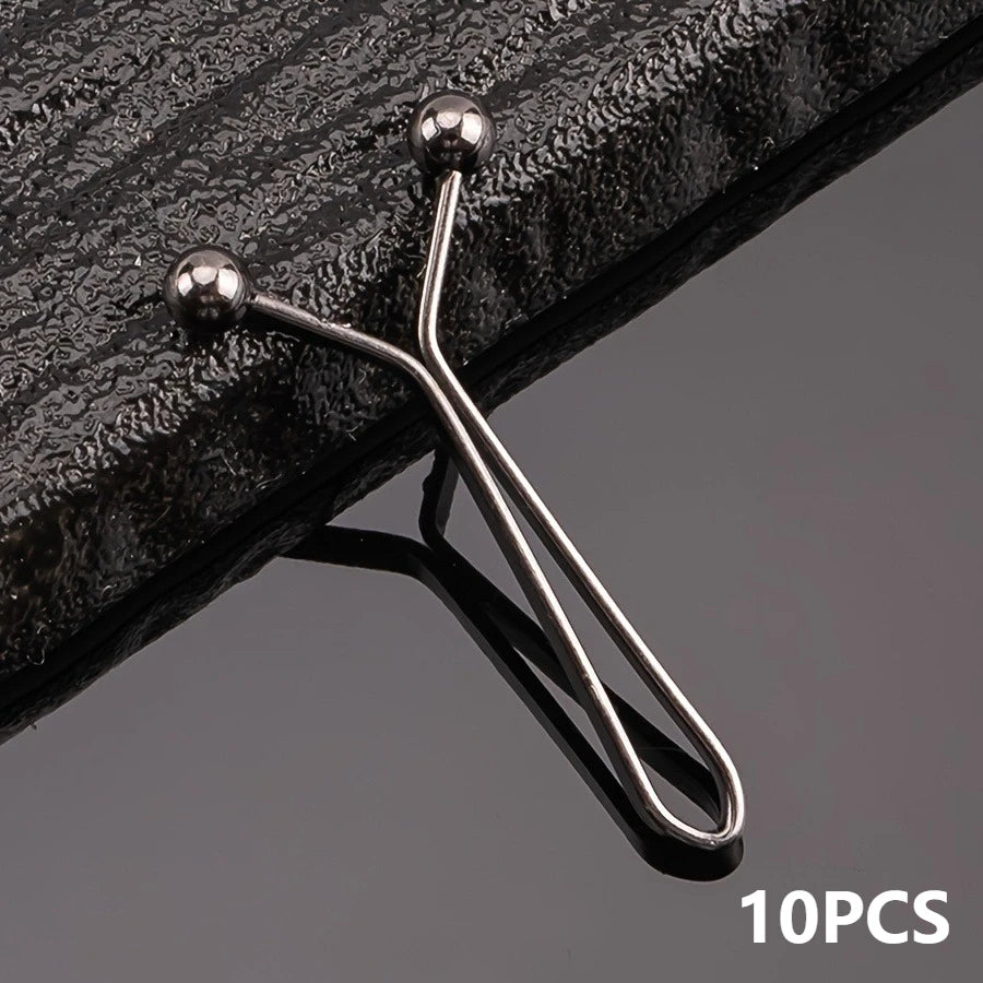 Ten metal lapel clips with spherical heads and thin arms are shown against a dark surface.