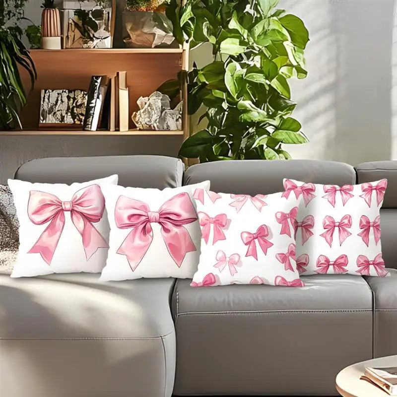 Decorative pillow covers featuring a pink bow pattern on white fabric displayed on a sofa.