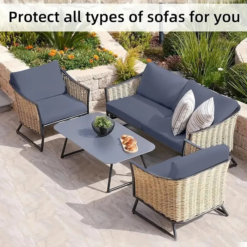 Outdoor wicker sofa set with gray cushions and a glass table in a garden setting