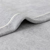 A close-up of a gray chenille sofa protector cover with a rolled edge.
