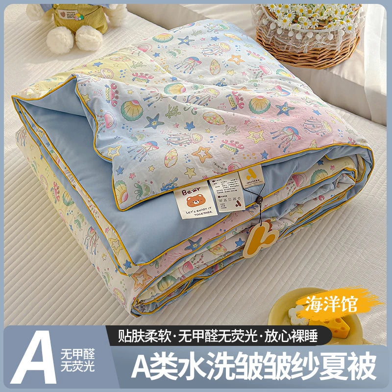 A lightweight summer quilt featuring a cartoon pattern, shown folded on a white surface.