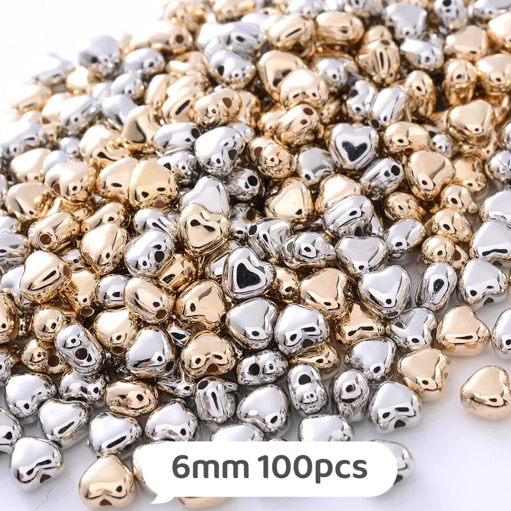 A mix of gold and silver heart-shaped geometric acrylic beads for jewelry making