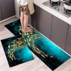 A set of two dark teal and gold diamond print non-slip kitchen rugs placed on a light wood floor.