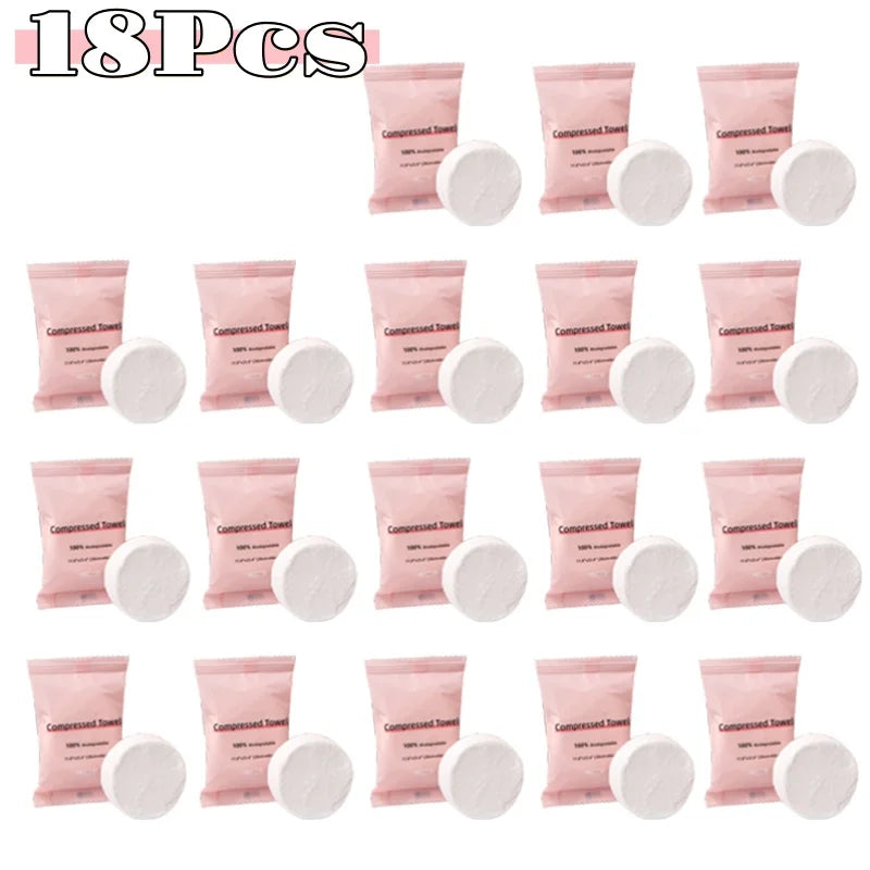 A collection of 18 pink compressed fiber face towels packaged in individual pouches.