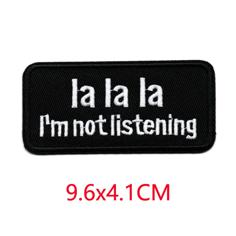 Black iron-on embroidered letter patch with white text that reads I'm not listening