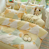 A beige and cream duvet and pillow set featuring a geometric pattern on a bed.