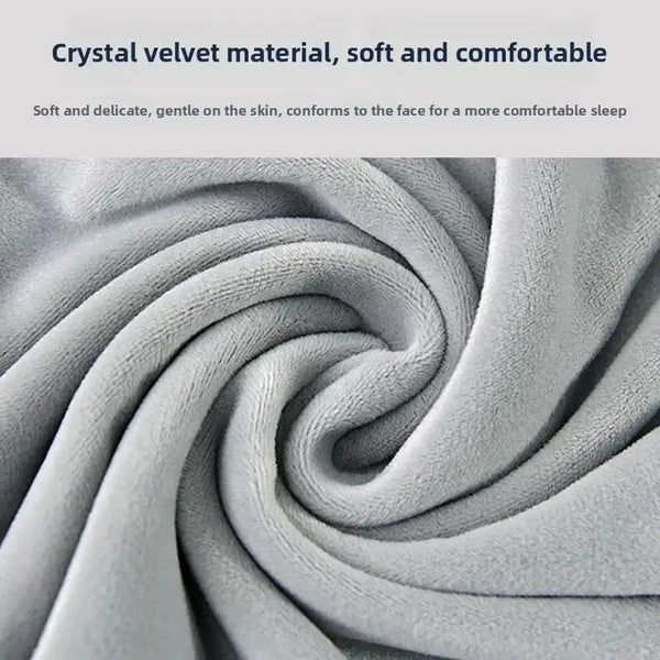 Close-up of a soft, gray velvet material forming a swirling pattern for a travel neck pillow.