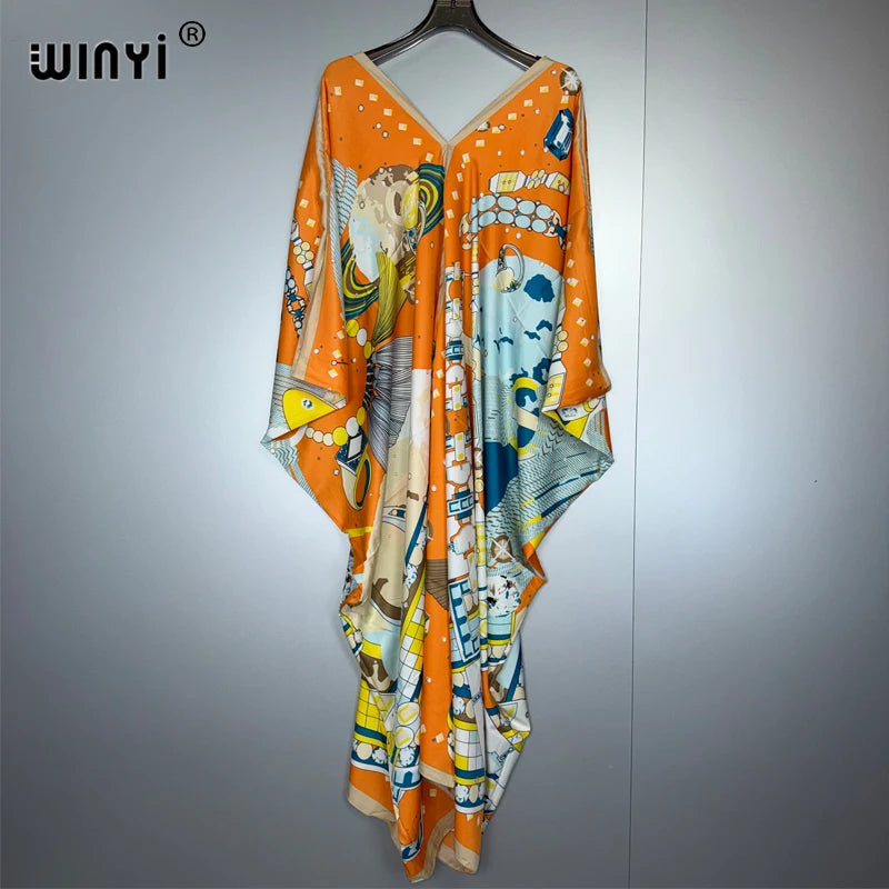 An orange and white boho floral print maxi dress hanging on a hanger.
