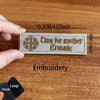 A beige embroidered patch with the text Time for another Crusade and a cross emblem is shown on a wooden surface.