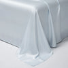 A smooth, light blue satin bed sheet draped elegantly on a white surface.